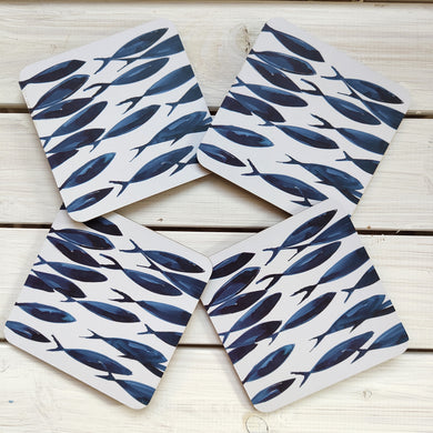 Four coasters with blue fish pattern on a wooden surface by Shoeless Joe