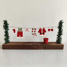 Santa's washing on a string with trees on either side against a white background by Shoeless Joe
