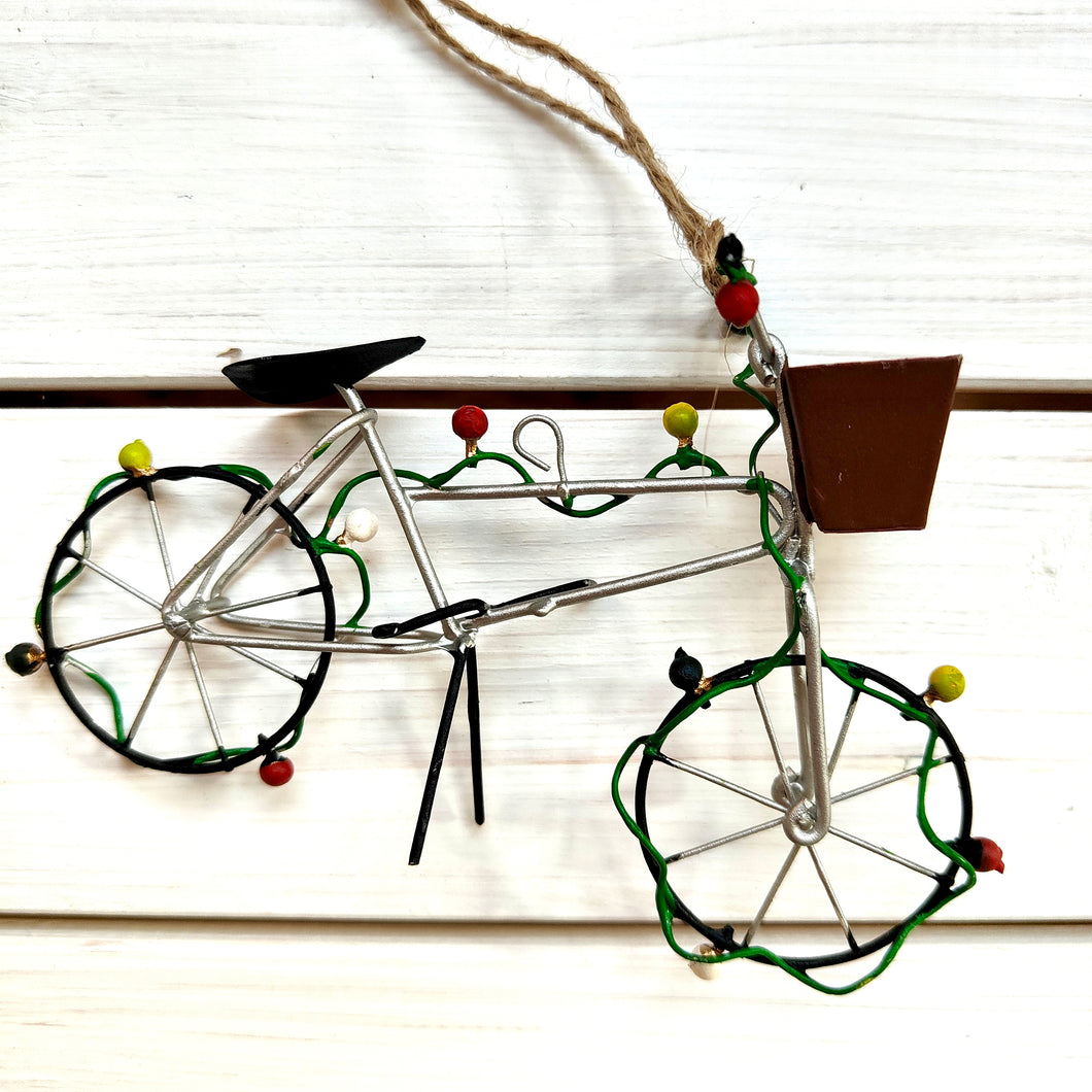 Decorative wire bicycle ornament on a white background featuring Christmas fairy lights.  By Shoeless Joe